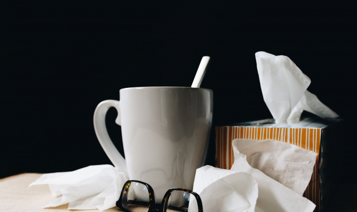 Picture of a hot drink and box of tissues on a desk